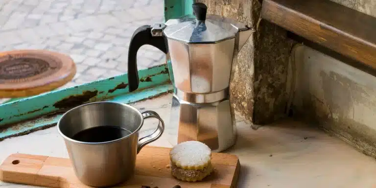 cafetière italienne avec le café et un gâteau en extérieur