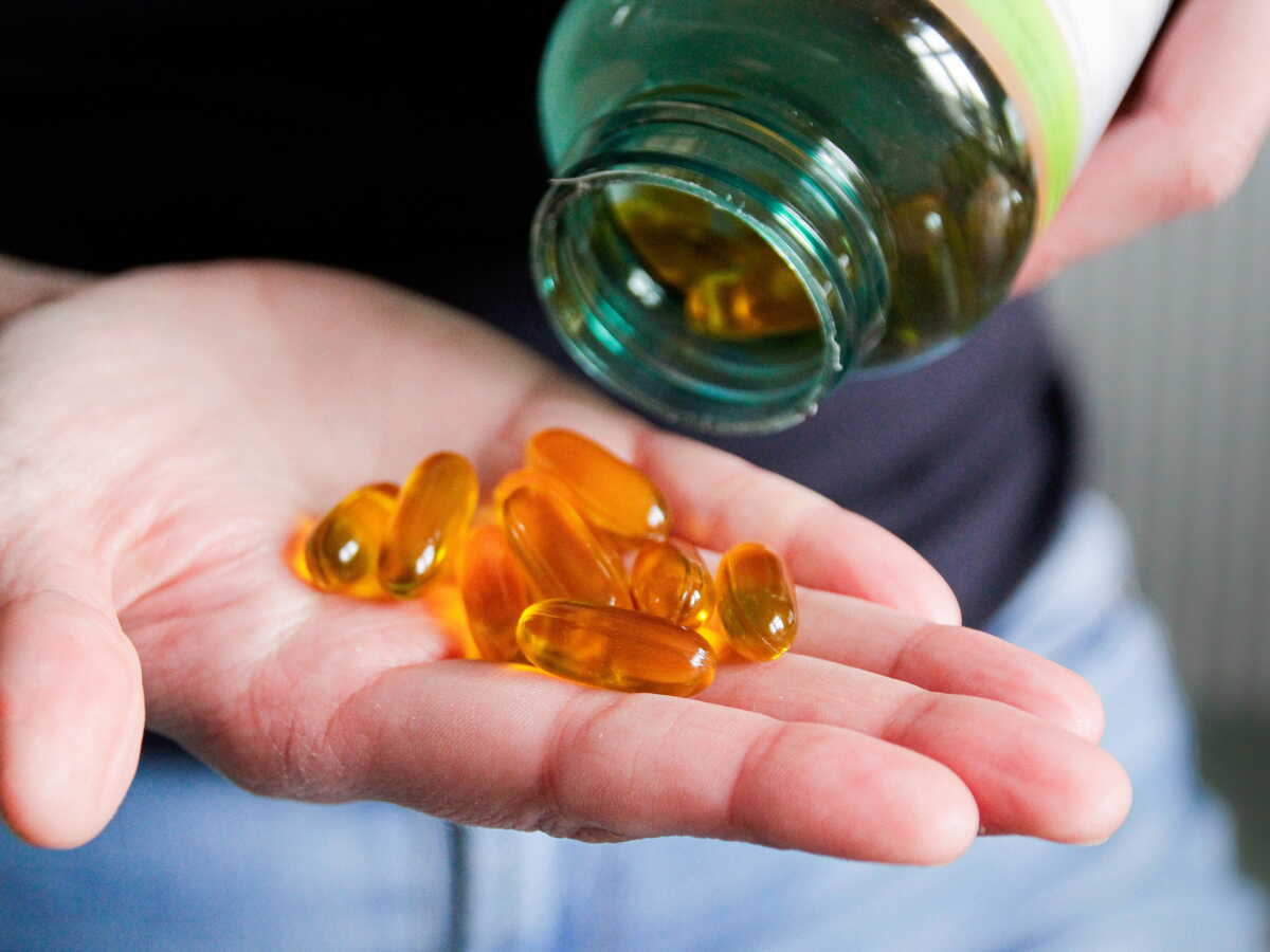 gélules compléments alimentaire dans la main d'un homme