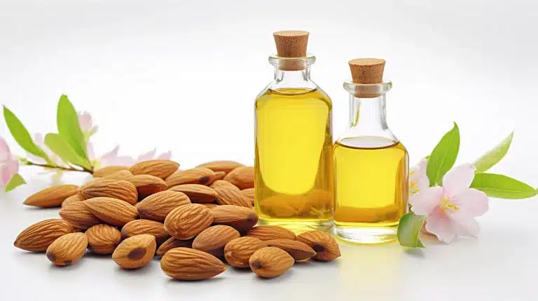 huile d'amande douce avec des amandes brutes à coté sur fond blanc