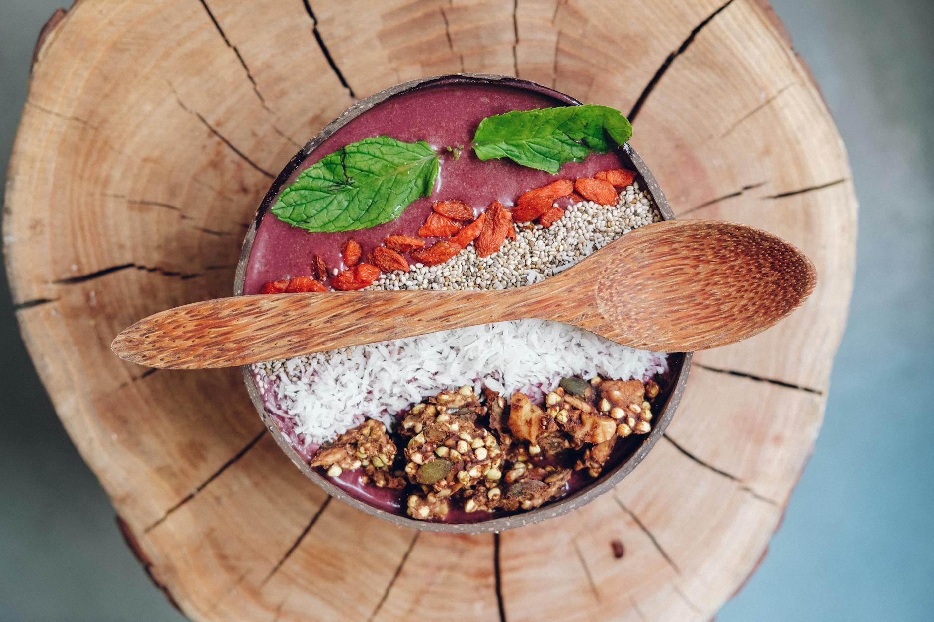 Femme préparant smoothie aux baies de goji et fruits frais en cuisine moderne