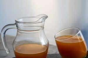 Jus d'abricot maison en carafe avec abricots frais coupés