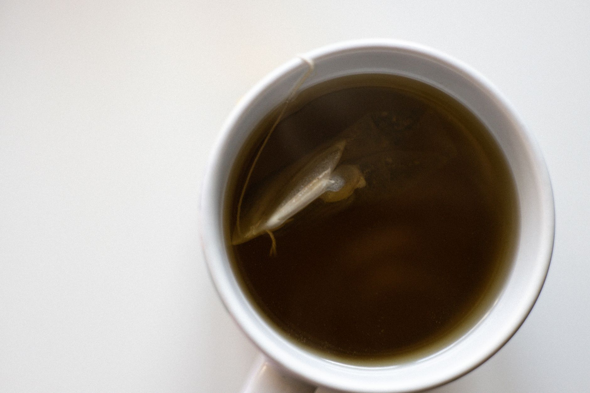 Tisane rhume au thym miel et citron dans une tasse fumante sur table en bois