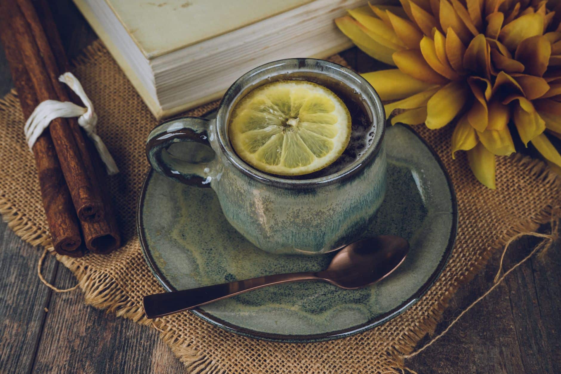 Tisane cannelle citron miel gingembre sur table bois