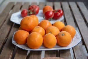 Oranges Navelina fraîches sur table en bois avec feuilles