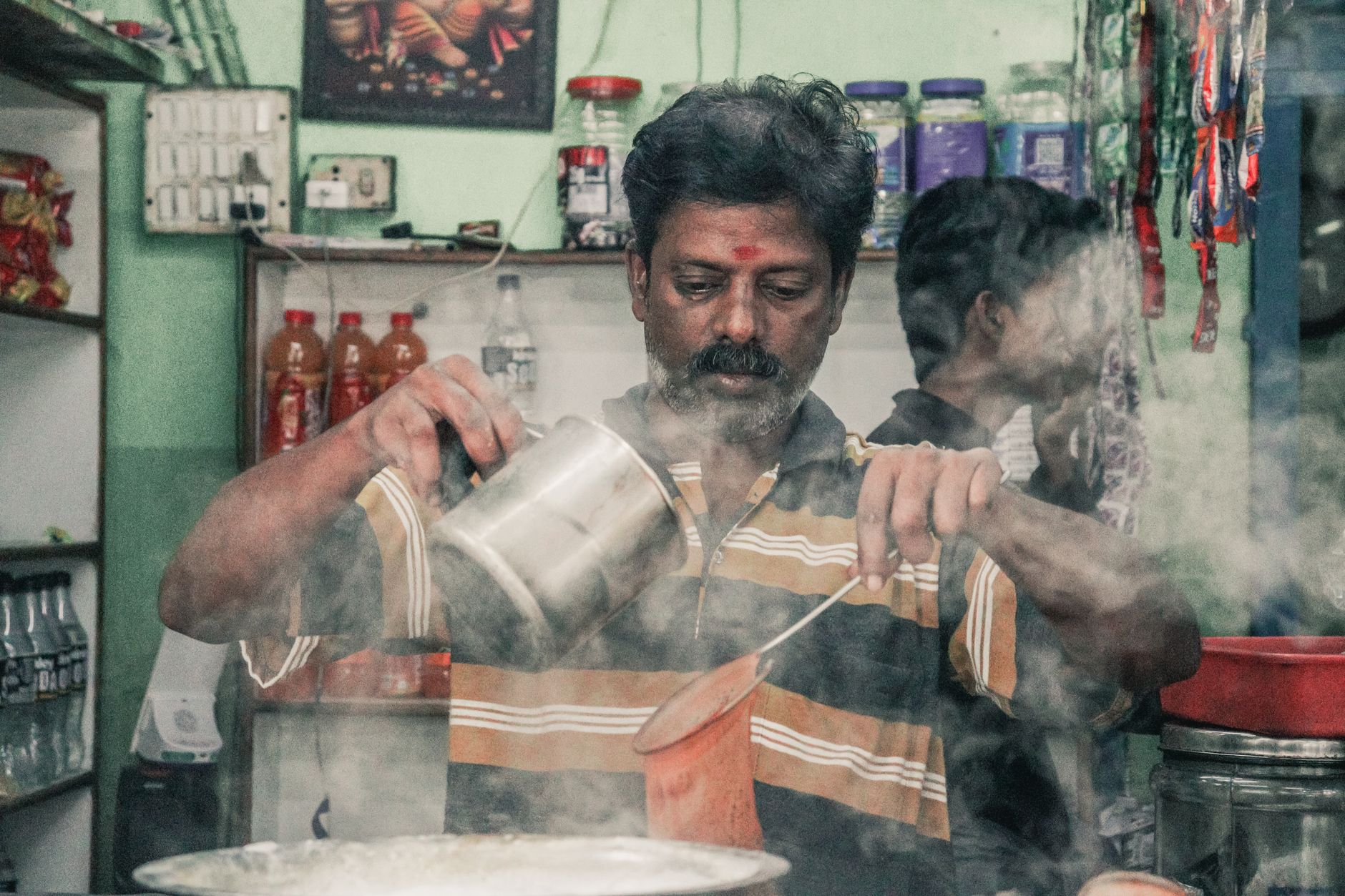Masala Chai indien traditionnel versé avec épices cardamome cannelle