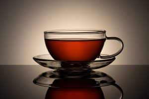 Tasse de thé gourmand vanille caramel sur table en bois