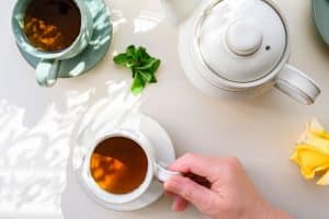 Tisane ballonnement fenouil menthe en tasse sur table bois