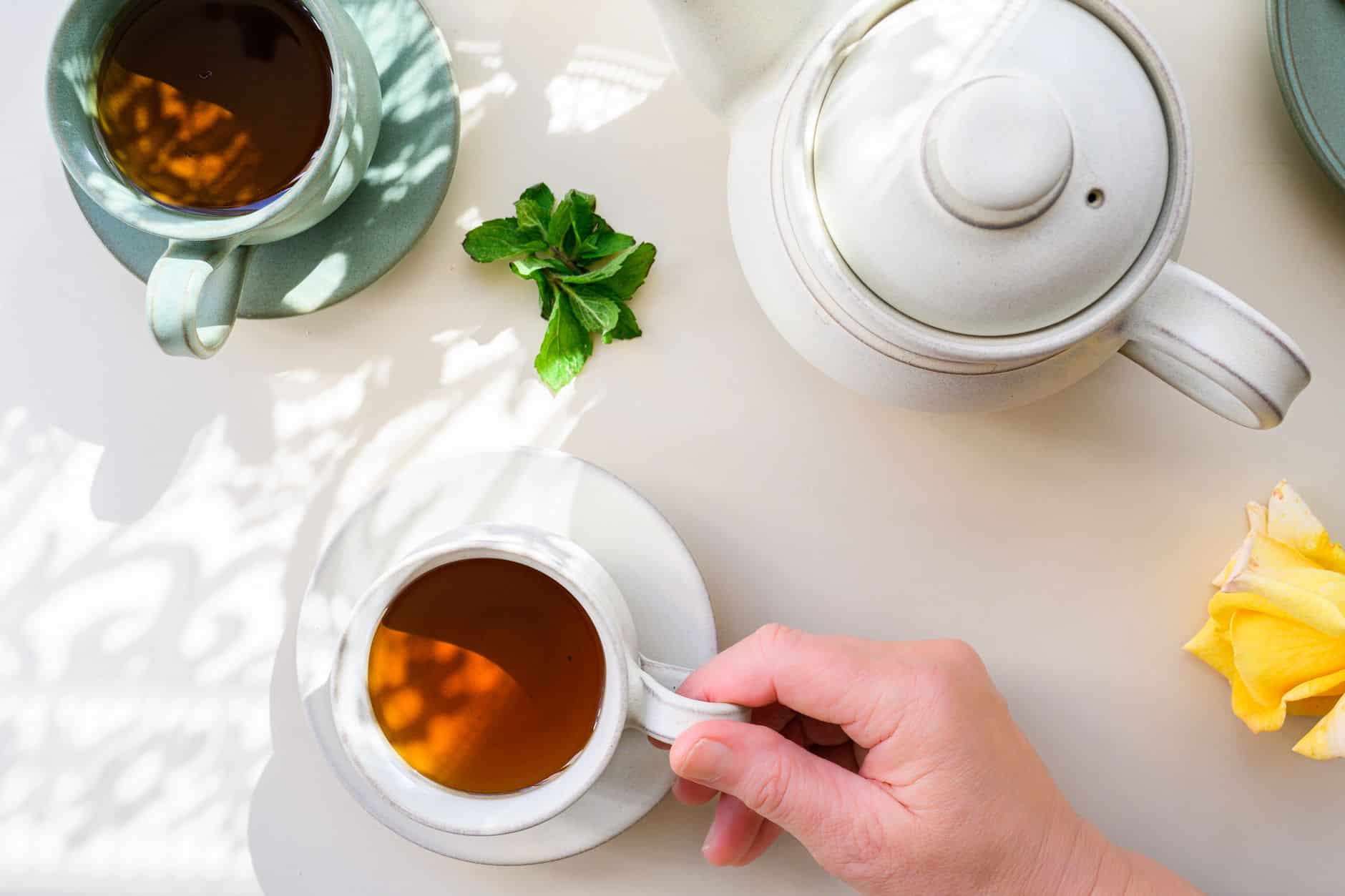 Tisane ballonnement fenouil menthe en tasse sur table bois